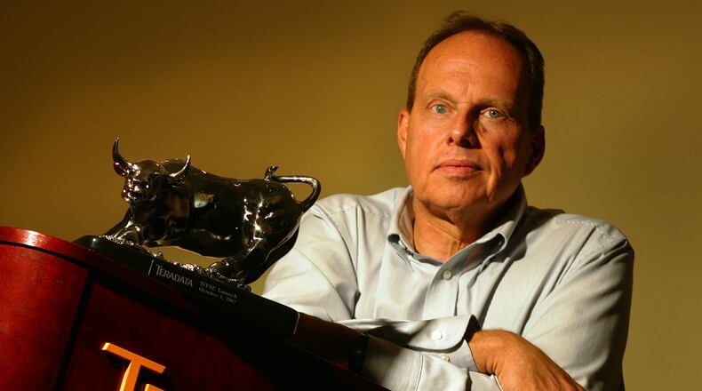 Bruce Langos, then the Teradata chief operations officer, with a bull statue given at the company's New York Stock Exchange launch October 1, 2007. Staff photo by Jim Witmer