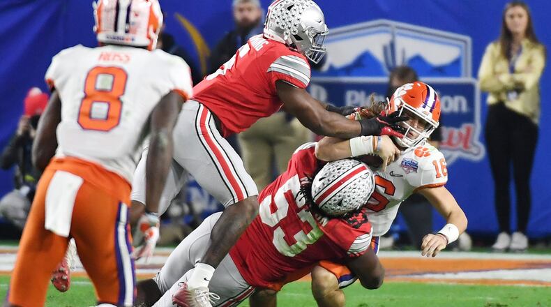 GLENDALE, ARIZONA - DECEMBER 28: Trevor Lawrence #16 of the Clemson Tigers is hit by Baron Browning #5 and Davon Hamilton #53 of the Ohio State Buckeyes in the second half during the College Football Playoff Semifinal at the PlayStation Fiesta Bowl at State Farm Stadium on December 28, 2019 in Glendale, Arizona. (Photo by Norm Hall/Getty Images)
