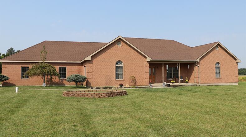 The brick house has about 2,650 sq. ft. of living space with 3 bedrooms and formal living and dining rooms. A gravel drive leads back along the mowed lawn to the side-entry, 2-car garage. CONTRIBUTED PHOTO BY KATHY TYLER