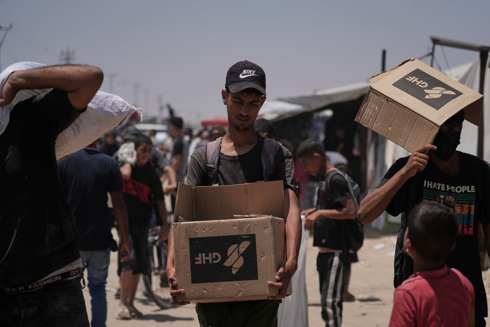 Palestinians carry bags and boxes containing food and humanitarian aid packages delivered by the Gaza Humanitarian Foundation, a U.S.-backed organization, in Rafah, southern Gaza Strip, Monday, June 16, 2025. (AP Photo/Abdel Kareem Hana)