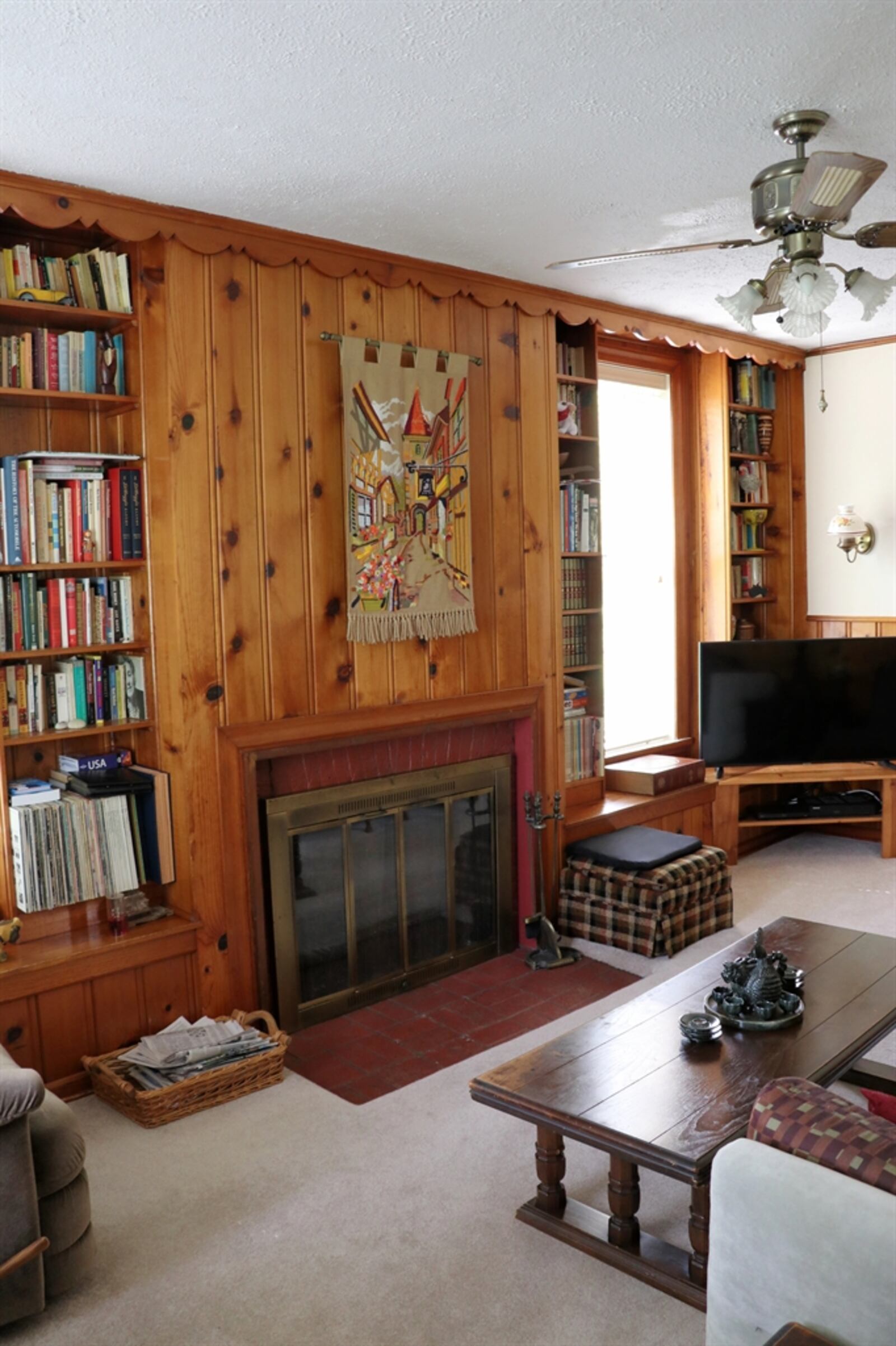 In the family room, knotty pine paneling accents the fireplace and some of the wall space.