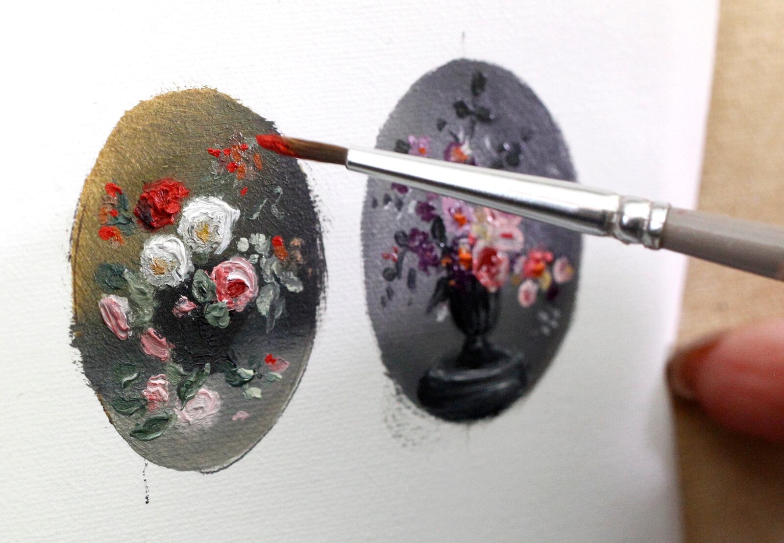 Cecilia Brendel uses delicate paint brushes and a magnifier for the detailed work within her miniature oil paintings. LISA POWELL / STAFF