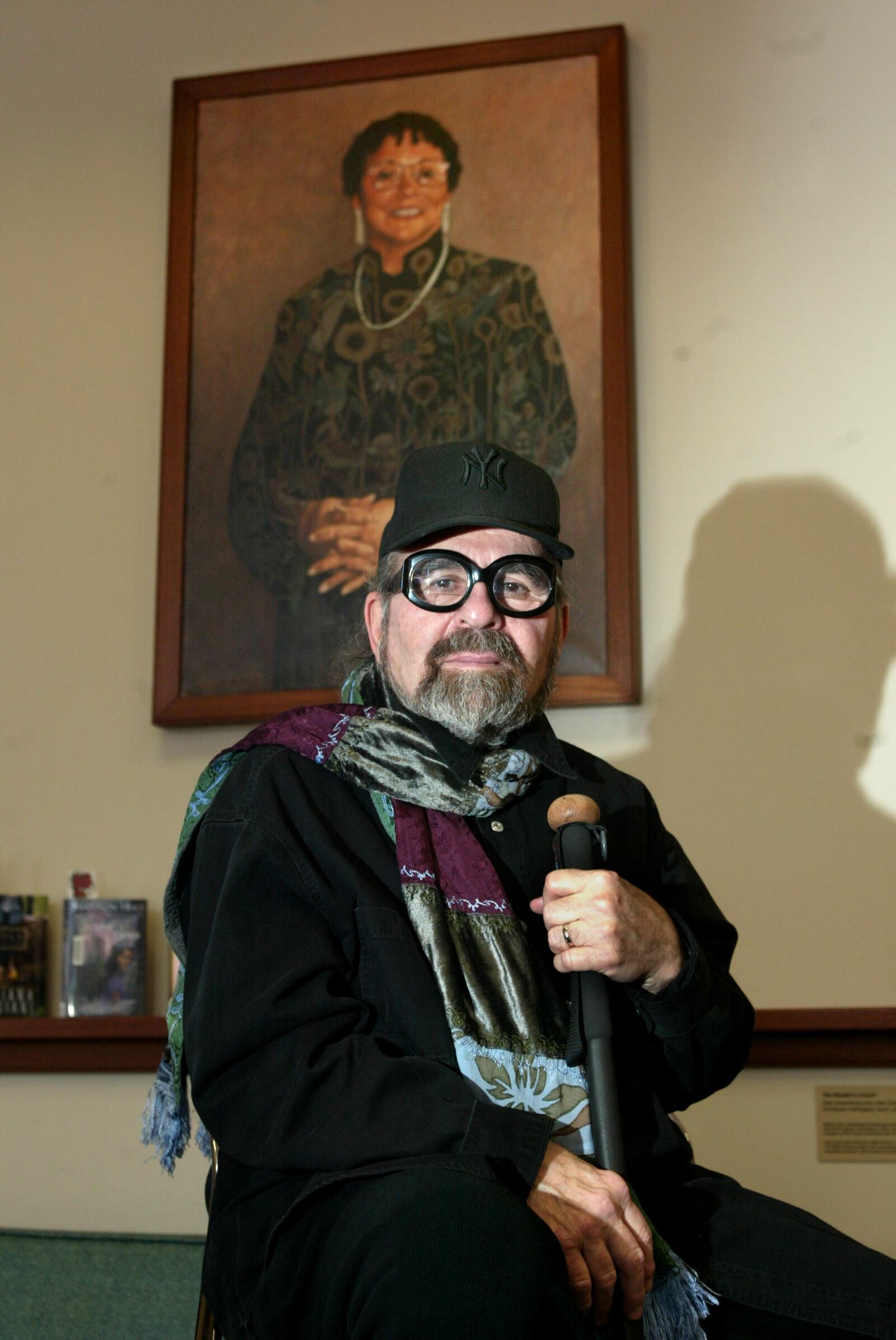 Arnold Adoff died May 7, 2021. Adoff, husband of the late Yellow Springs author Virginia Hamilton, is pictured in 2010 at the Yellow Springs library with a portrait of Hamilton. JAN UNDERWOOD / STAFF FILE