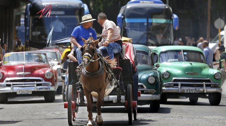 Tourist buses share the road along with vintage American cars and a horse drawn buggy in Havana, Cuba, in March 2016. (Al Diaz/Miami Herald/TNS)
