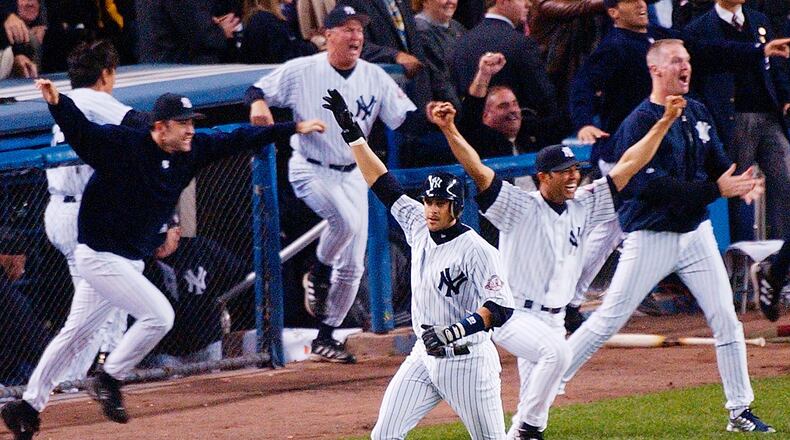 FILE - In this Oct. 16, 2003, file photo, New York Yankees' Aaron Boone, center, celebrates after hitting a solo home run in the 11th inning to beat the Boston Red Sox in Game 7 of the American League Championship Series in New York. Boone became the first person with no experience as a manager of coach to interview to become Joe Girardi's successor with the New York Yankees. The 44-year-old interviewed Friday, Nov. 17, 2017, becoming the fourth to go through the process after Yankees bench coach Rob Thomson, former Cleveland and Seattle manager Eric Wedge, and San Francisco bench coach Hensley Meulens. (AP Photo/Bill Kostroun, File) ORG XMIT: NY184
