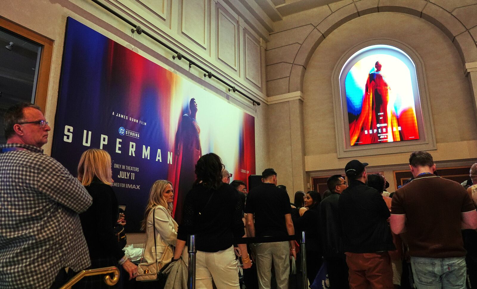 CinemaCon attendees wait for entry underneath advertisements for the upcoming film "Superman" before the Warner Bros. Pictures presentation at CinemaCon on Tuesday, April 1, 2025, at Caesars Palace in Las Vegas. (AP Photo/Chris Pizzello)