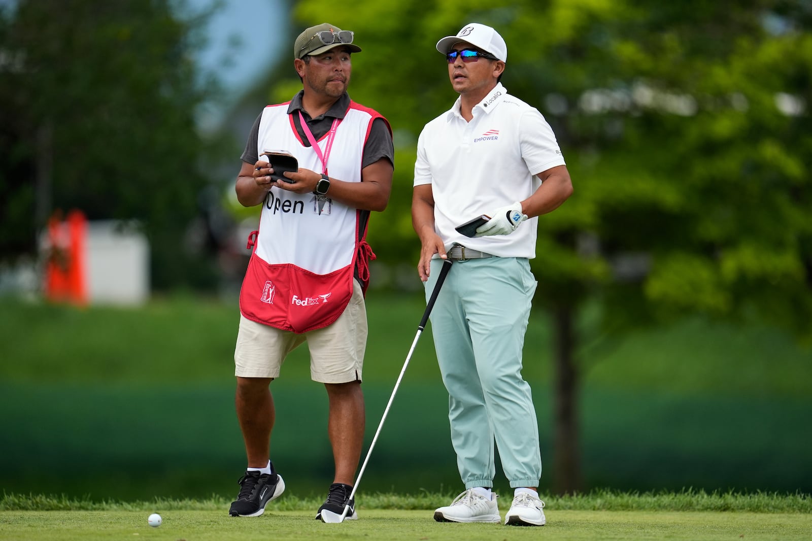 Kurt Kitayama, right, stands with his caddie, Daniel Kitayama, at the tenth tee during the final round of the 3M Open golf tournament at the Tournament Players Club Sunday, July 27, 2025, in Blaine, Minn. (AP Photo/Abbie Parr)
