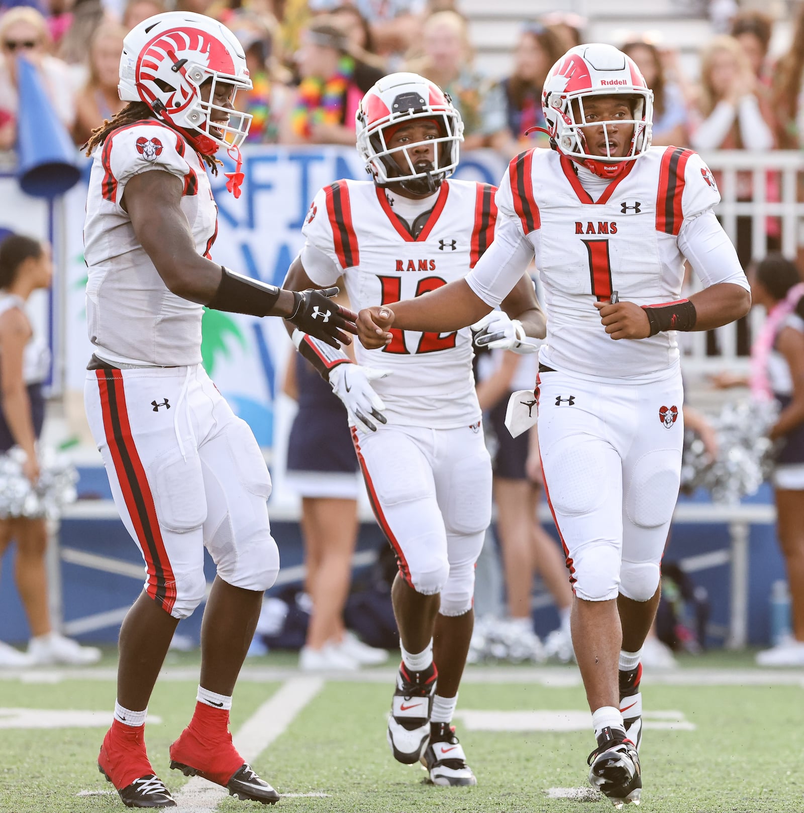 Trotwood-Madison senior quarterback Dallas Shehee (right) celebrates with Dishawn Peterson (left) and Tristen Bozeman (center) after Shehee scored on an 11-yard TD run in the second quarter of a nonconference game against Fairmont on Friday, Aug. 29 at Roush Stadium in Kettering. BRYANT BILLING / STAFF