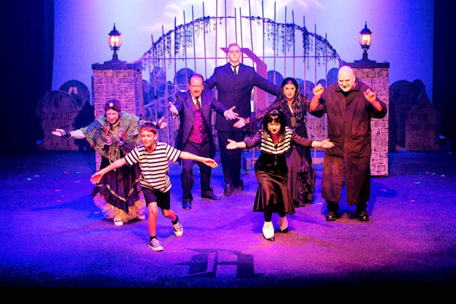 Left to right: Kelli Myers (Grandma), Liam Cockerham (Pugsley), Ron Maurer (Gomez), David Laws (Lurch), Brianna Wolfe (Wednesday), Taylor Nelson (Morticia) and Jason S. Lakes (Uncle Fester) in Dayton Playhouse's production of "The Addams Family." Photo by Ray Geiger