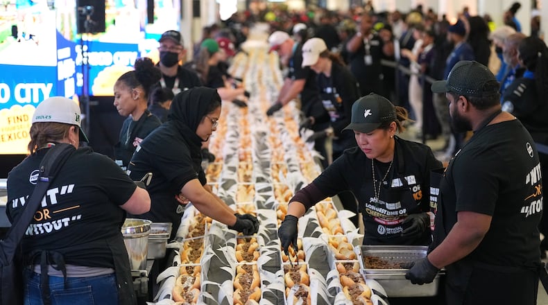 Volunteers assemble cheesesteaks in a Guinness World Record attempt on National Cheesesteak Day at Philadelphia International Airport, Tuesday, March 24, 2026, in Philadelphia. (AP Photo/Matt Rourke)