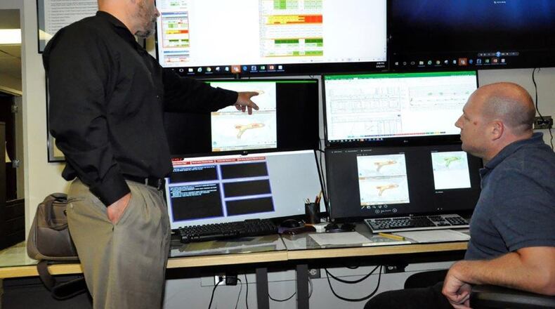 88th Operations Support Squadron’s Weather Flight weather forecaster Eric McGee (left) and meteorologist Scott Lutz discuss an archived Doppler Weather Radar image of a supercell hook echo from the night of May 27 when tornadoes damaged a wide range of areas in the Miami Valley. (U.S. Air Force photo/Caroline Clauson)