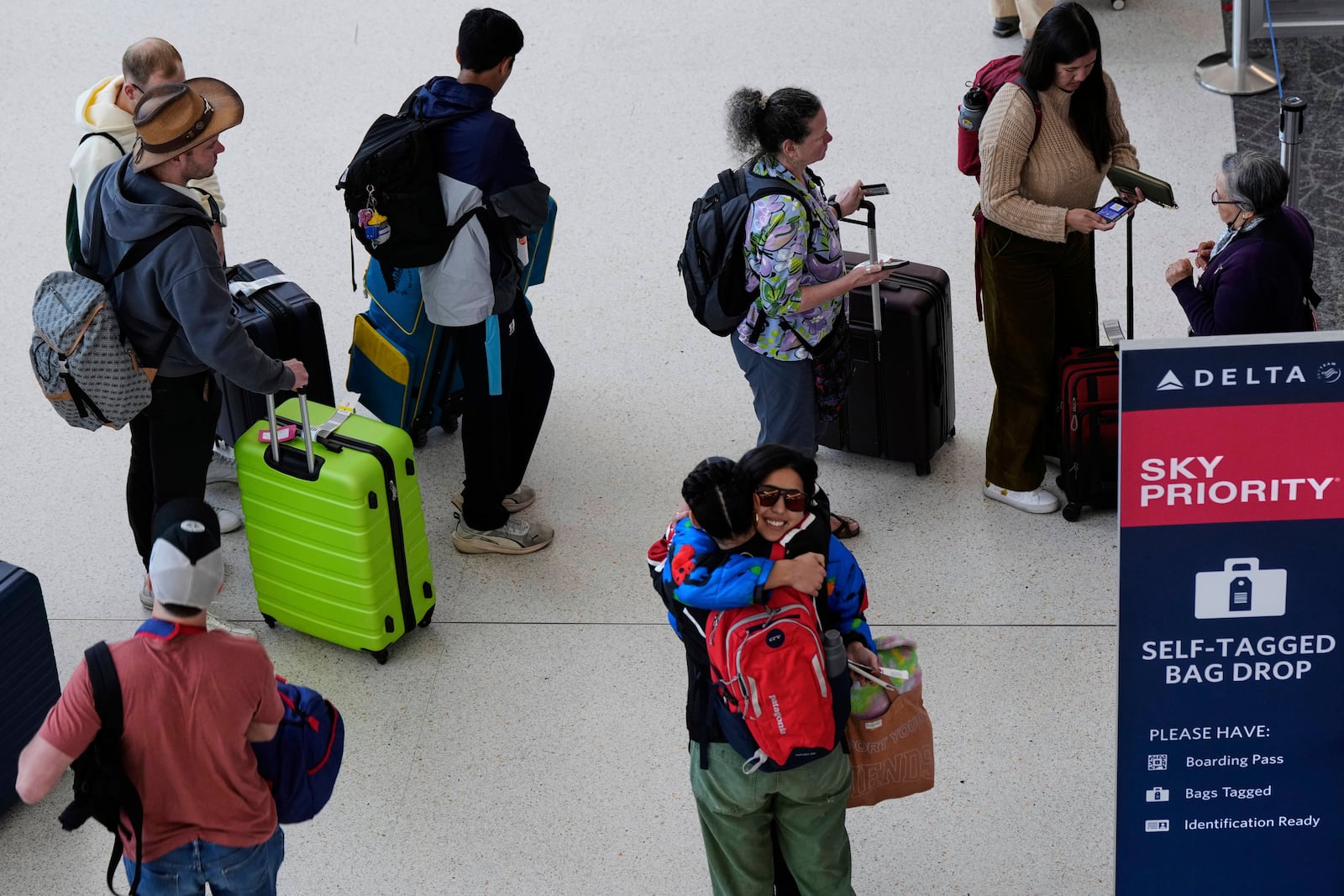 Travelers wait in line to check-in their luggage at San Francisco International Airport ahead of the Memorial Day holiday weekend in San Francisco, Thursday, May 22, 2025. (AP Photo/Godofredo A. Vásquez)