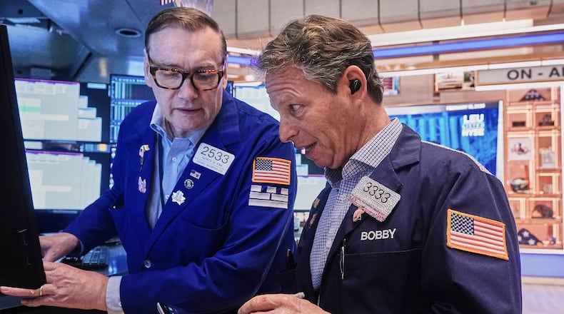 Specialist Patrick King, left, and trader Robert Charmak work on the floor of the New York Stock Exchange, Thursday, Feb. 19, 2026. (AP Photo/Richard Drew)