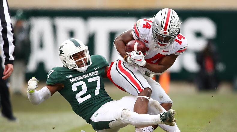 EAST LANSING, MI - NOVEMBER 10: K.J. Hill #14 of the Ohio State Buckeyes battles for yards after a second half catch while being tackled by Khari Willis #27 of the Michigan State Spartans at Spartan Stadium on November 10, 2018 in East Lansing, Michigan. (Photo by Gregory Shamus/Getty Images)