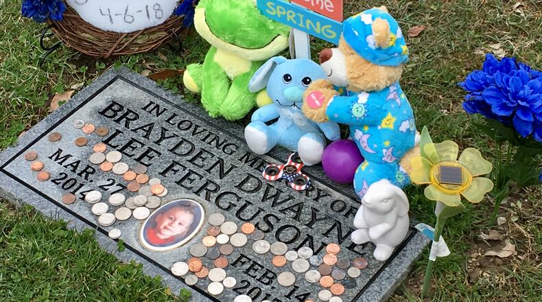 Toys and a handmade wreath declaring "I Got Justice 4-6-18" adorn Brayden Ferguson's grave site at Dayton Memorial Park.