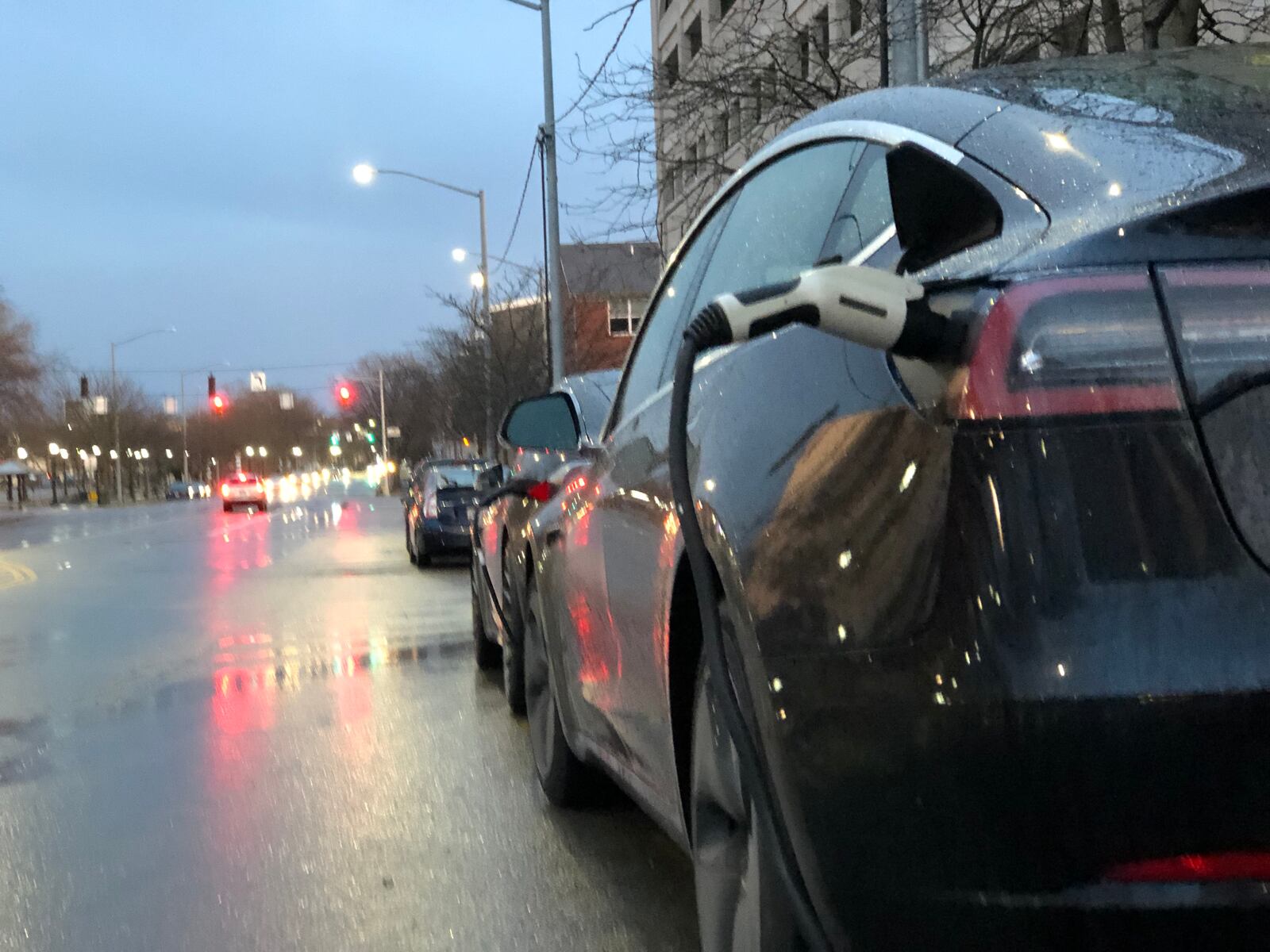 A vehicle is charged at an electric charging station in downtown Dayton, near Day Air Ballpark. CORNELIUS FROLIK / STAFF
