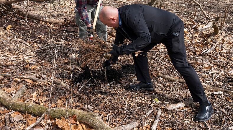 Staff Sgt. Clayton Nyp turns over a shovel of dirt so Eric Edem can place a seedling in the hole April 7 on Wright-Patterson Air Force Base. The two 88th Security Forces Squadron members were among a group of volunteers who helped plant 180 seedlings of native trees along Trout Creek near Huffman Prairie, where the Wright brothers learned how to fly. U.S. AIR FORCE PHOTO/R.J. ORIEZ