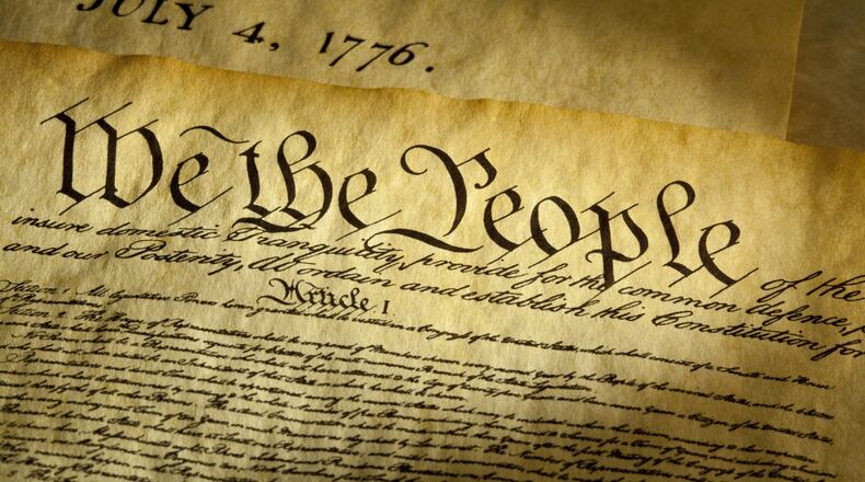 We the People are the opening words of the preamble to the Constitution of the USA. The document underneath is a copy of the Declaration of Independence with the date, July 4, 1776 showing.