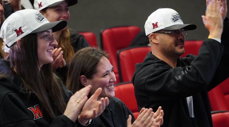 Miami's Amber Tretter (left) and Tamar Singer (center) celebrate with RedHawks coach Glenn Box (right) during an NCAA Tournament Selection Show watch party on Sunday in Oxford. CHRIS VOGT / CONTRIBUTED