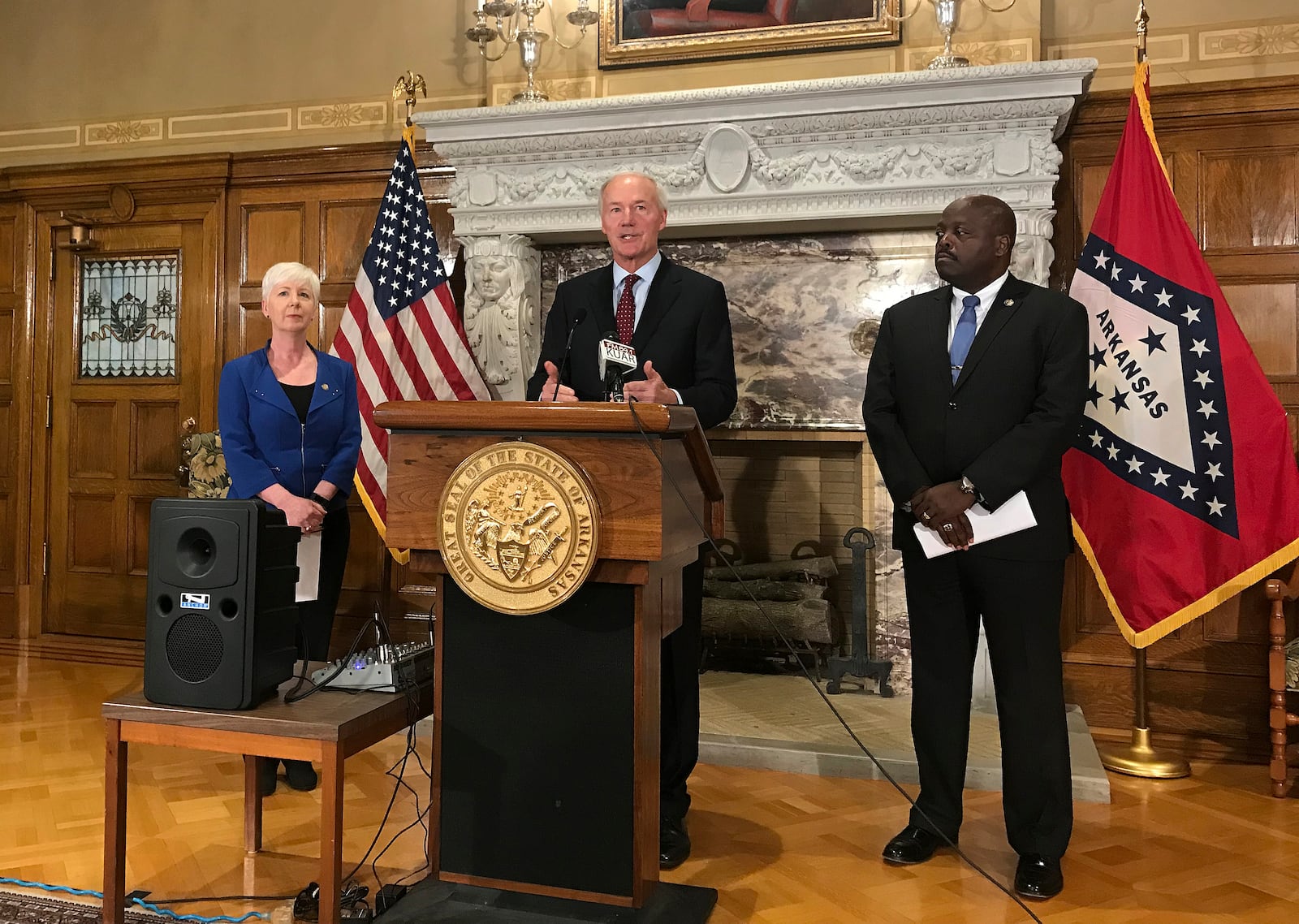 FILE - In this Sept. 12, 2018, file photo, Arkansas Gov. Asa Hutchinson, center, talks at a news conference at the State Capitol in Little Rock, Ark., about the state's work requirement for its expanded Medicaid program. (AP Photo/Andrew DeMillo, File)