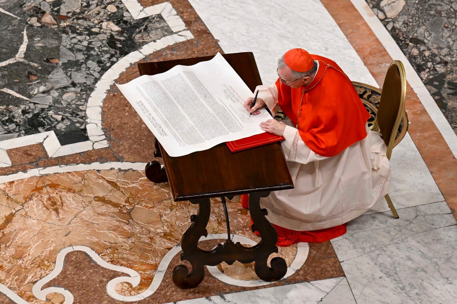 Cardinal Camerlengo Kevin Joseph Farrel signs the official deed of late Pope Francis before closing his casket in St. Peter's Basilica at the Vatican Friday, April 25, 2025. (Vatican Media via AP)