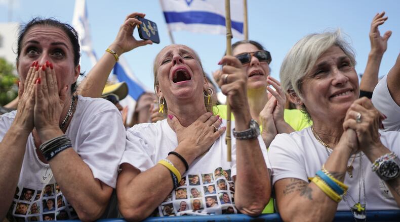 People react as they gather to watch a live broadcast of Israeli hostages released from Gaza at a plaza known as hostages square in Tel Aviv, Israel, Monday, Oct. 13, 2025. (AP Photo/Oded Balilty)