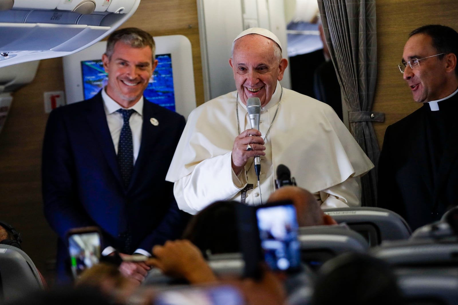 FILE - Pope Francis is flanked by his spokesperson Matteo Bruni, left, as he addresses journalists during his flight from Rome to Maputo, Mozambique, Wednesday, Sept. 4, 2019. "It’s an honor if the Americans attack me.” -- Quip to French journalist-author Nicholas Seneze, referring to U.S. conservative criticism, aboard the papal plane. (AP Photo/Alessandra Tarantino, file)