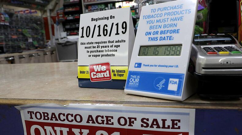 Signs on the counter at the Plum Food Mart in Springfield inform customers that they must by 21-years-old to purchase tobacco and vaping products as of Wednesday, Oct. 16, 2019. BILL LACKEY/STAFF