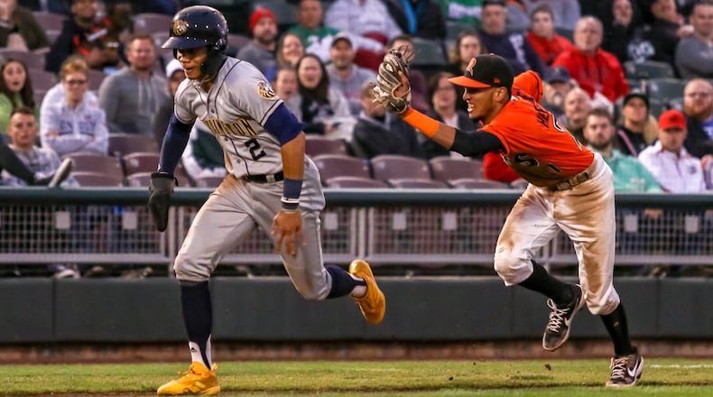 Dayton Dragons shortstop Miguel Hernandez reaches out to tag Burlington’s Jordyn Adams during a rundown between third base and home plate on Friday night at Fifth Third Field. Adams was safe on the play and the the Dragons lost 9-4. CONTRIBUTED PHOTO BY MICHAEL COOPER