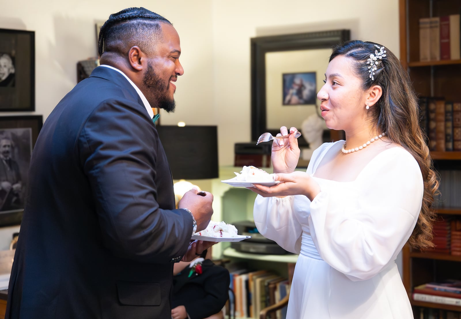 Xavier Castillo (left) and Selena Huerta-Marquez (right) react after feeding each other cake following a wedding ceremony in Dayton attorney Isabel Suarez's apartment on Friday, Dec. 26. BRYANT BILLING/STAFF