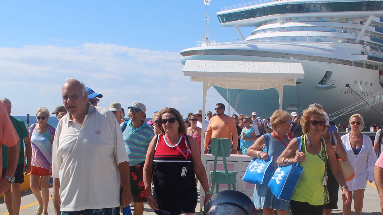 Passengers, many beach-bound and all undiscouraged by the cannon, disembark from Princess Cruises&apos; Crown Princess, left, and Silversea&apos;s Silver Muse at Grand Turk. (Alan Solomon/Chicago Tribune/TNS)