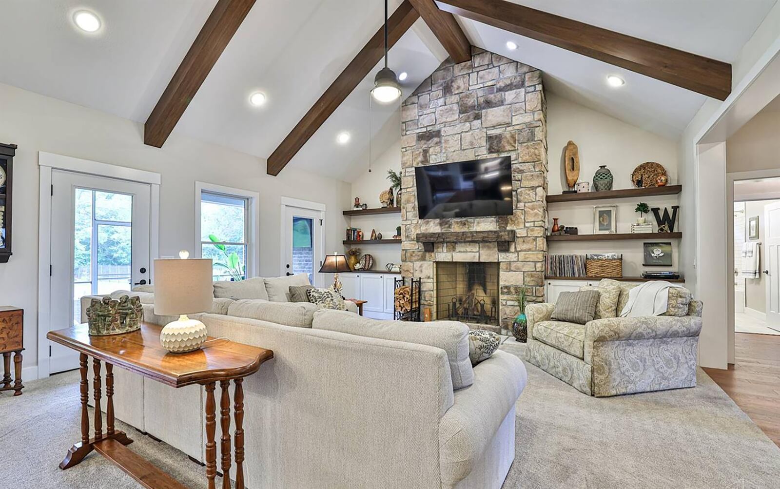 The great room has vaulted beamed ceilings and a floor to ceiling stone woodburning fireplace. CONTRIBUTED