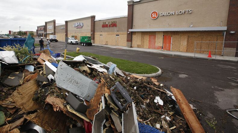 Most of the stores in the Shoppes at Fairfield Commons have been boarded up due to tornado damage. Piles of debris have been collected for removal as damage is assesed by insurers. TY GREENLEES / STAFF