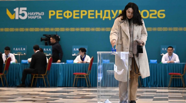 In this photo released by Kazakhstan's President Press Office, a woman casts her ballot at a polling station during a referendum on a new constitution, in Astana, Kazakhstan, Sunday, March 15, 2026. (Kazakhstan's President Press Office via AP)