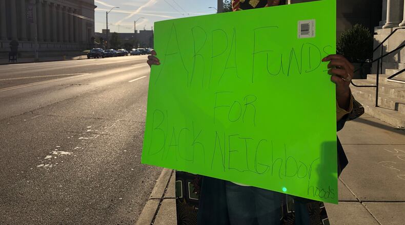 A small group of protestors gathered outside of City Hall to demand the city of Dayton push back its deadline for applications for federal rescue funds. Protestors held signs with messages like, "ARPA funds for Black neighborhoods." CORNELIUS FROLIK / STAFF