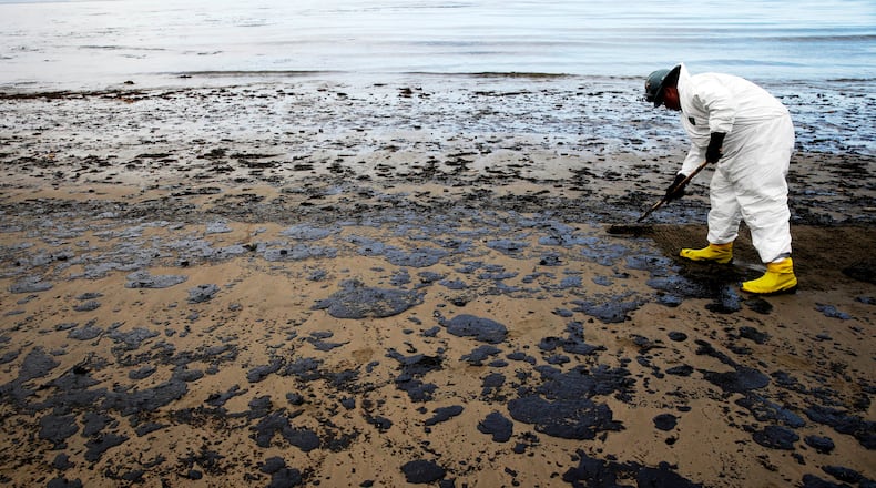 FILE - A worker removes oil from sand at Refugio State Beach, north of Goleta, Calif., on May 21, 2015. (AP Photo/Jae C. Hong, File, File)