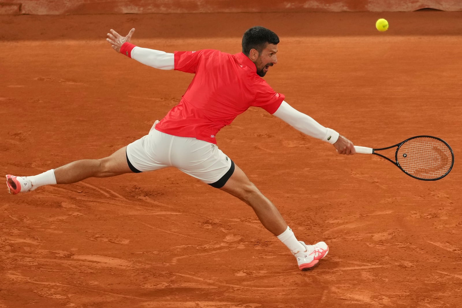 Serbia's Novak Djokovic returns the ball to Mackenzie McDonald of the U.S. during their first round match of the French Tennis Open, at the Roland-Garros stadium, in Paris, Tuesday, May 27, 2025. (AP Photo/Thibault Camus)