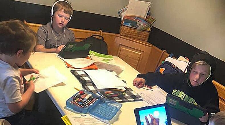 Northmont students (clockwise from left) Reid Harrison, 7, Dane Harrison, 9, Owen Sanders, 11 and Finn Harrison, 8, do schoolwork at their kitchen table at home. SUBMITTED PHOTO