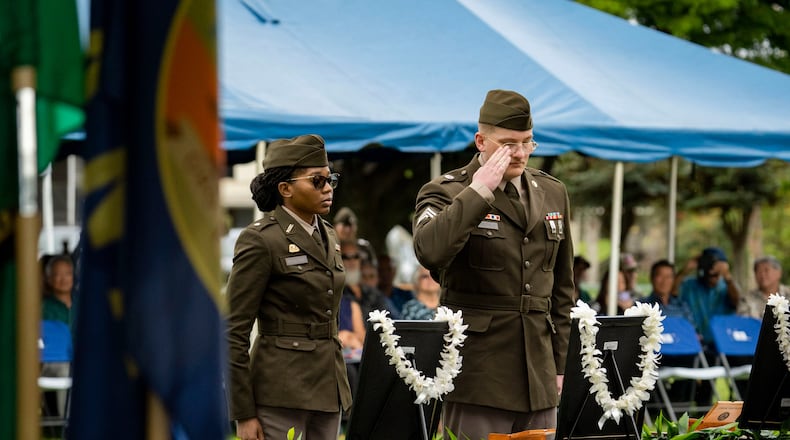 U.S. Army soldiers salute framed photos of former University of Hawaii ROTC cadets during a posthumous commissioning ceremony at Ke'ehi Lagoon Memorial Park, Monday, Jan. 26, 2026, in Honolulu. (AP Photo/Mengshin Lin)