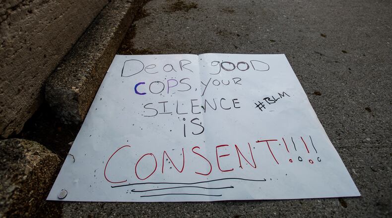 Signs, debris and graffiti damage were left in downtown Dayton Sunday morning, May 31, after protests throughout the day on Saturday in the aftermath of the death of George Floyd. CIty and county workers, business owners and volunteers spent the morning sweeping up glass and scrubbing spray paint. NICK GRAHAM / STAFF