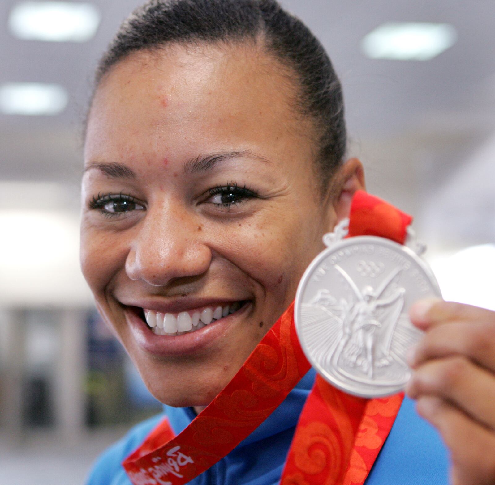 26 Aug 08 Photo by Ron Alvey. Hyleas Fountain, standing in the Dayton International Airport, shows the silver medal that she recently won in the Olympics. She finished in second place while competing in the heptathlon at the Beijing Olympics.