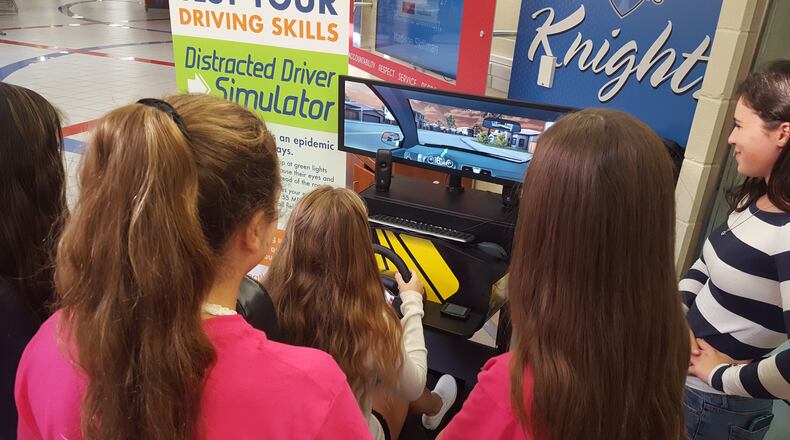 Kings High School students try out a simulator during a special event set up by the Ohio Department of Transportation as part of efforts to reduce teen crashes.