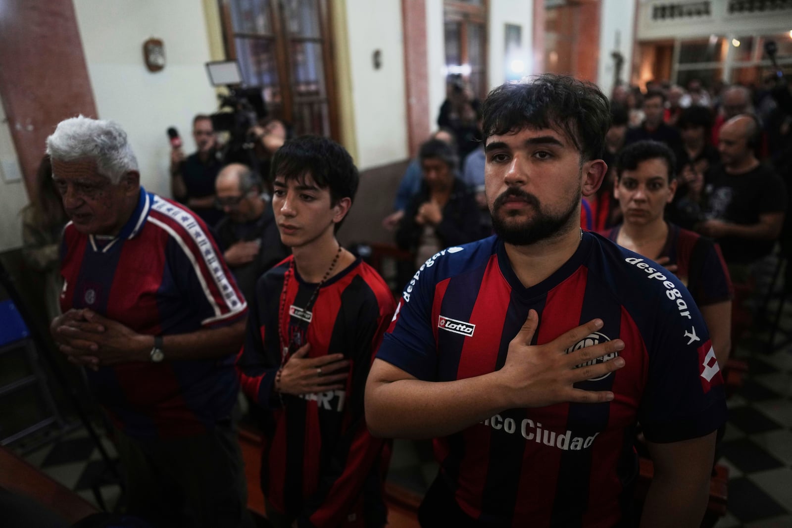 Fans of San Lorenzo soccer club attend a Mass at San Antonio Parish in honor of the late Pope Francis, a lifelong supporter of the club, in Buenos Aires, Argentina, Wednesday, April 23, 2025. (AP Photo/Natacha Pisarenko)