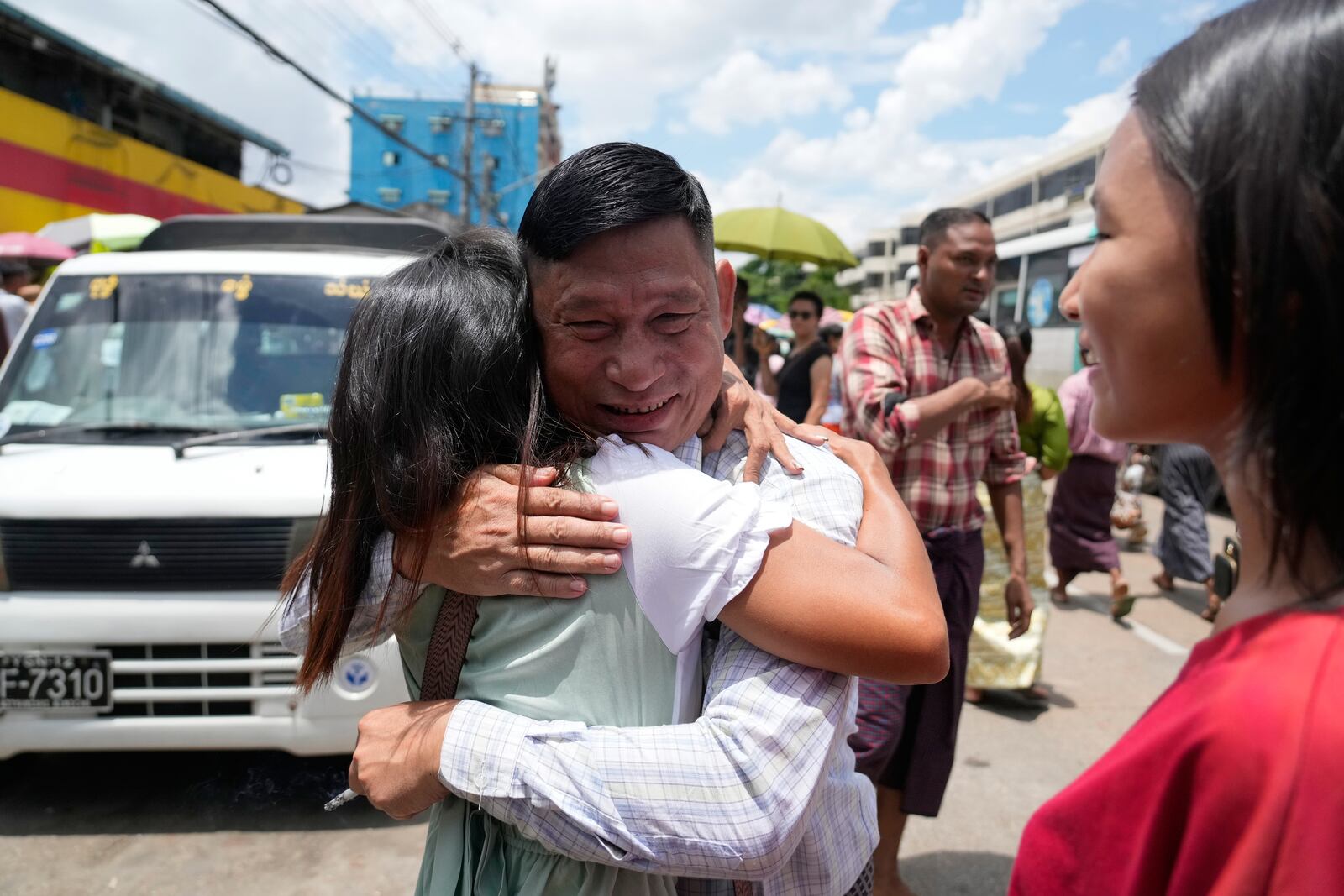 A released prisoner, center, is welcomed by family members outside the main gate of Insein prison as the head of Myanmar’s military government granted amnesty to thousands of prisoners to mark the country's traditional New Year Thursday, April 17, 2025, in Yangon, Myanmar. (AP Photo/Thein Zaw)