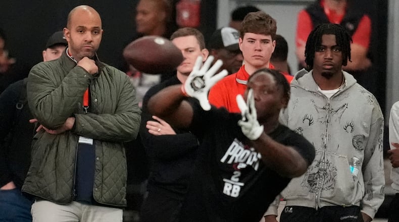 Ian Cunningham, general manager of the Atlanta Falcons, left, watches players work out during the school's NFL football pro day, Wednesday, March 18, 2026, in Athens, Ga. (AP Photo/Mike Stewart)