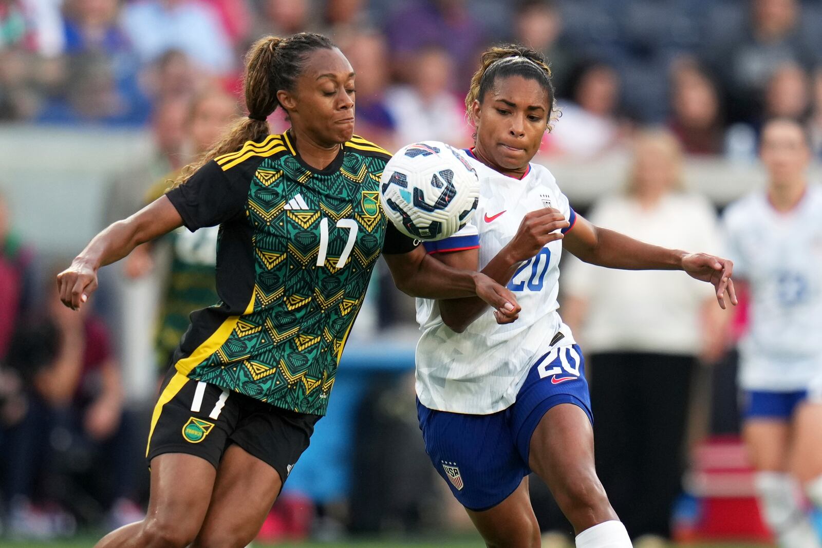 Jamaica's Allyson Swaby (17) and United States' Catarina Macario (20) battle for the ball during the first half of an international friendly soccer match Tuesday, June 3, 2025, in St. Louis. (AP Photo/Jeff Roberson)