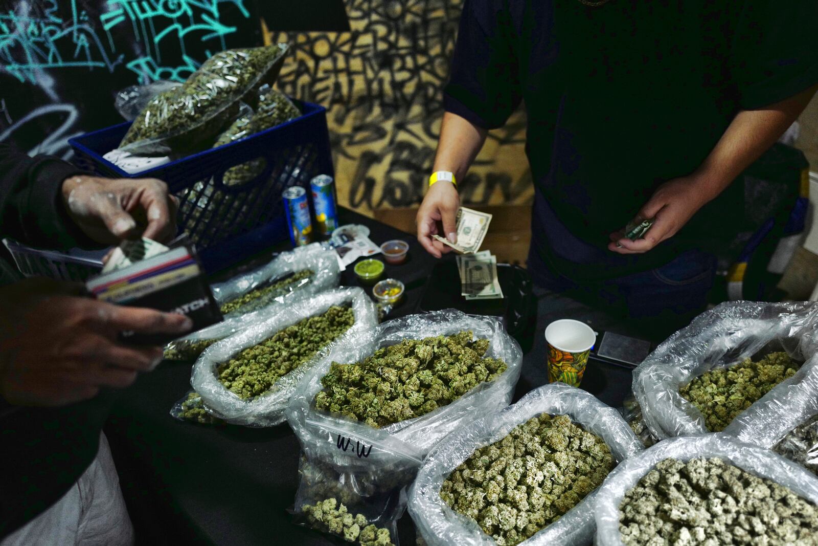 FILE - A vendor makes change for a marijuana customer at a cannabis marketplace in Los Angeles, April 15, 2019. (AP Photo/Richard Vogel, File)