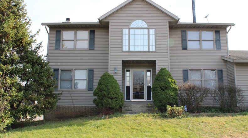 The front of the vinyl-sided, two-story home features a concrete walk, covered entry and storm door covering the front door. There are double sidelights flanking the front door. Contributed photo