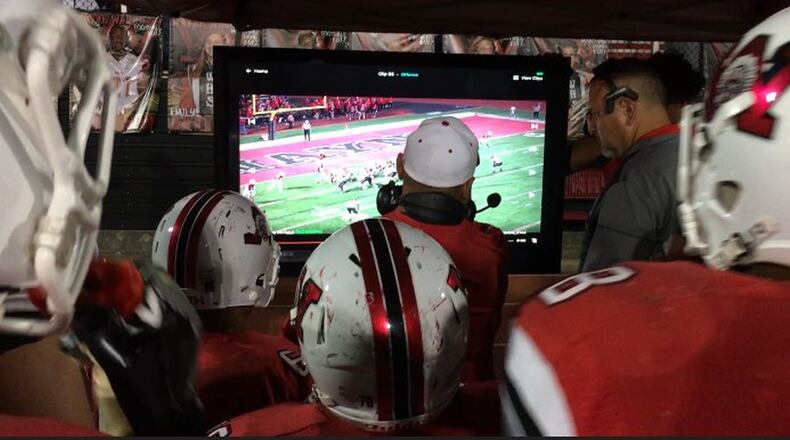 Wayne players gather around assistant coaches for video replay during a recent game. MARC PENDLETON / STAFF