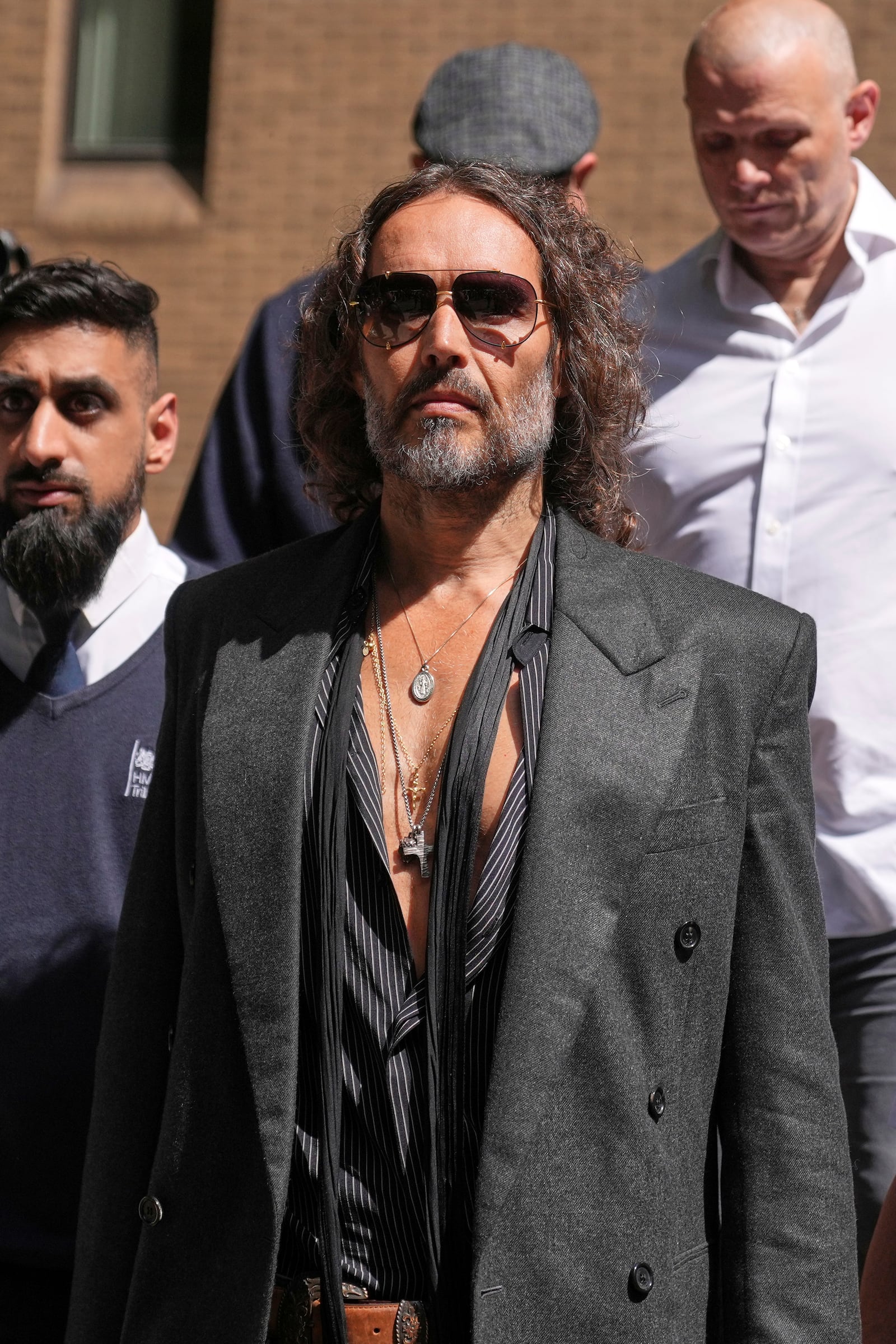 English comedian and actor Russell Brand leaves Southwark Crown Court where he is charged with rape and sexual assault in London, Friday, May 30, 2025.(AP Photo/Alastair Grant)